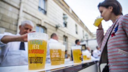 Les assoiffés se pressent devant la buvette éphémère pour acheter une bière sans alcool (3 euros) servie dans un gobelet recyclable siglé "Élysée, Fête de la musique". (CHRISTOPHE PETIT TESSON / AFP)