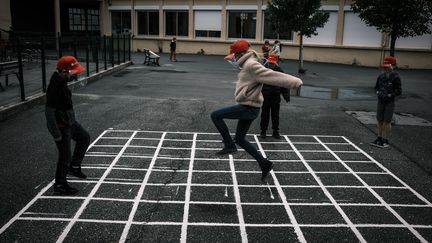 Des élèves jouent dans la cour de l'école élémentaire de La Grand-Croix (Loire), le 12 mai 2020. (JEAN-PHILIPPE KSIAZEK / AFP)