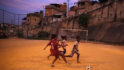 Des enfants jouent au football dans une favela de Rio de Janeiro (Br&eacute;sil), le 22 mai 2014. (PILAR OLIVARES / REUTERS)