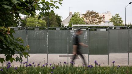 Un passant devant des panneaux utilisés pour l'affichage électoral, à Nantes (Loire-Atlantique), lundi 6 mai 2019.&nbsp; (JEREMIE LUSSEAU / HANS LUCAS / AFP)