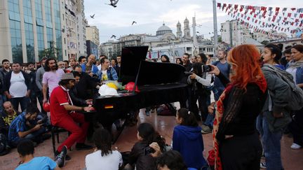 Davide Martello, un pianiste allemand, joue au centre de la place Taksim &agrave; Istanbul (Turquie),&nbsp;lieu embl&eacute;matique des manifestations hostiles au Premier ministre turc, le 14 juin 2013. (MURAD SEZER / REUTERS)