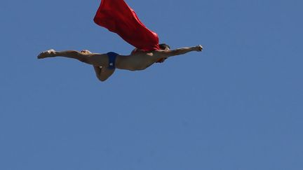 Le Tch&egrave;que Michel Navratil s'&eacute;lance du plongeoir de 27 m&egrave;tres avec une cape lors d'un show en marge des championnats du monde de natation &agrave; Barcelone (Espagne), le 31 juillet 2013. (GUSTAU NACARINO / REUTERS)