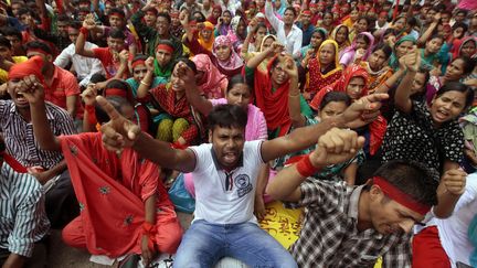 Manifestation d'ouvriers du textile pour un salaire minimum de 100 dollars par mois &agrave; Dacca, au Bangladesh, le 13 septembre 2013.&nbsp; (A.M. AHAD / AP / SIPA )