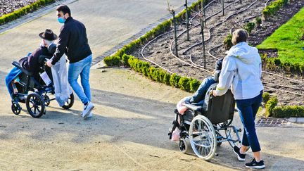 Un homme et une femme poussent deux personnes en fauteuil roulant dans un jardin du Mans (Sarthe), le 29 janvier 2021. (GILE MICHEL / SIPA)