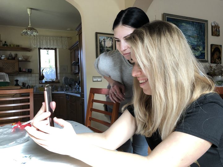 Ola (left) and Oksana (right), talk on the phone with their husbands back in Ukraine, March 1, 2022, from Bieniewice (Poland).  (RAPHAEL GODET / FRANCEINFO)