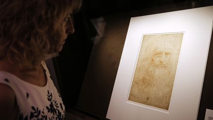 Une femme regarde un autoportrait de Léonard de Vinci à la bibliothèque de Turin (Italie). (MARCO BERTORELLO / AFP)