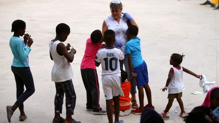 Un volontaire joue avec des enfants migrants, interceptés à bord d’un canot au large des côtes dans le détroit de Gibraltar, à Los Barrios, près d’Algeciras, dans le sud de l’Espagne, le 1er août 2018.&nbsp; (JON NAZCA / SIPA)