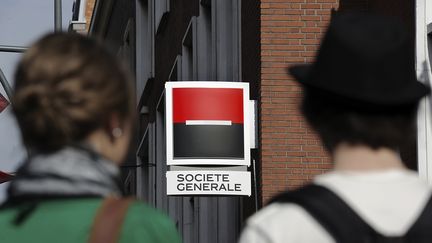 Des passants devant une agence de la Soci&eacute;t&eacute; g&eacute;n&eacute;rale &agrave; Dunkerque (Nord), le 10 ao&ucirc;t 2011. (PHILIPPE HUGUEN / AFP)