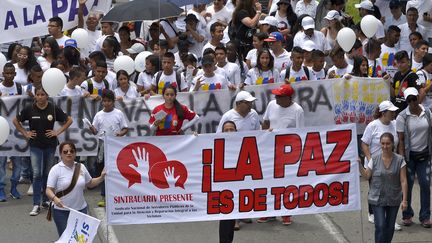 Des manifestants défilent dans les rues de Cali (Colombie) pour un accord de paix entre les Farc et le gouvernement, le 9 octobre 2016. (LUIS ROBAYO / AFP)