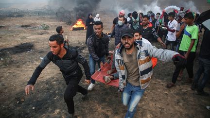 Des manifestants évacuent l'un de leurs blessés, le 26 octobre 2018 à Gaza. (HASSAN JEDI / ANADOLU AGENCY / AFP)