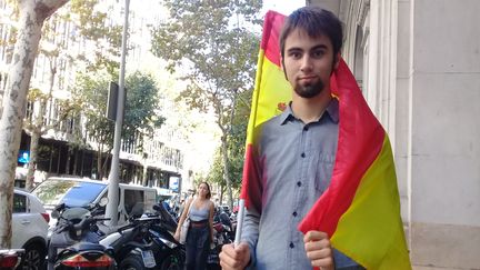 Ernesto Lopèz, drapeau espagnol sur les épaules, dans les rues de Barcelone (Espagne), le 5 octobre 2017. (RAPHAEL GODET / FRANCEINFO)