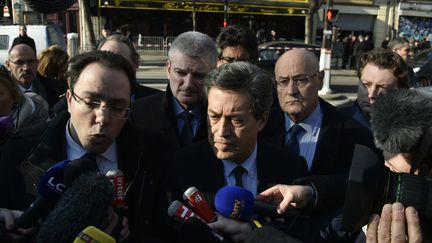 Les députés membres de la commission d'enquête parlementaire présidée par Georges Fenech (au centre) répondent aux journalistes avant d'entrer dans le Bataclan, le 17 mars 2016, dans le 11e arrondissement de Paris.&nbsp; (ALAIN JOCARD / AFP)