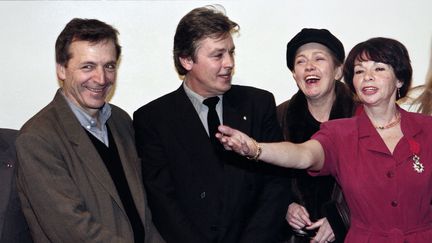 Le réalisateur Costa-Gavras et l'acteur Alain Delon, après avoir reçu la Légion d'honneur, à Paris, le 29 mars 1991. (GILLES LEIMDORFER / AFP)