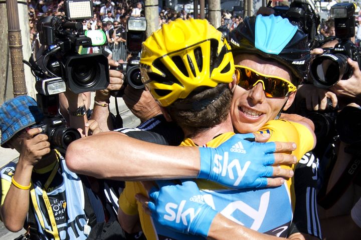 Chris Froome étreint son leader, Bradley Wiggins, porteur du maillot jaune, à l'arrivée du Tour de France 2012 aux Champs-Elysées, le 22 juillet. (JEFF PACHOUD / AFP)