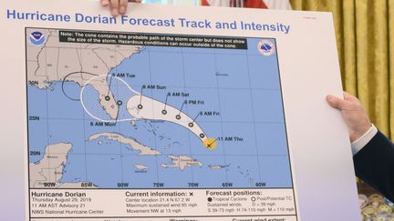 Le président américain, Donald Trump, montre une carte de la trajectoire initialement prévue de l'ouragan Dorian, agrémentée d'un trait tracé au crayon noir, le 4 septembre 2019, à la Maison Blanche. (JIM WATSON / AFP)