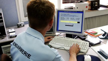 Un gendarme de la cellule "cybercriminalit&eacute;"&nbsp;copie le disque dur d'un ordinateur afin d'en v&eacute;rifier le contenu, le 16 septembre 2005 &agrave; Lille (Nord). (FRANÇOIS LO PRESTI / AFP)