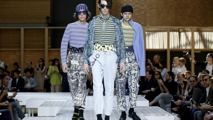 Chez Kenzo, les Américains Carol Lim et Humberto Leon ont rendu hommage à la culture du clubbing des années 1990 dans un défilé survitaminé, mêlant la collection masculine à des silhouettes féminines. "L'âme d'une ville réside dans sa vie nocturne. Nés à Los Angeles, nous avons grandi avec les clubs de la côte ouest, rêvant aux nuits new-yorkaises", expliquent les deux créateurs quadragénaires dans leur note d'intention. Les jaunes sont acides, les imprimés psychédéliques. Avec les mini-shorts, les chaussettes se portent bien remontées. Le corsaire moulant est une autre option. Les filles sont juchées sur des chaussures à plateforme très disco.
 (YOAN VALAT/EPA/MaxPPP)