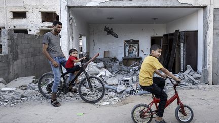 Des Palestiniens devant un immeuble détruit par des frappes israéliennes, le 20 juin 2023, sur la bande de Gaza (Palestine). (SAMEH RAHMI / NURPHOTO / AFP)