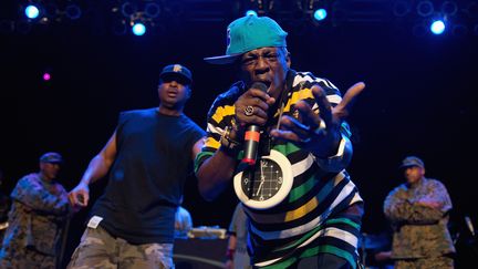 Flavor Flav (avec la pendule au premier plan) et Chuck D. (à gauche), lors d'un concert de Public Enemy le 5 décembre 2012 à la House of Blues de Chicago (Illinois, Etats-Unis). (DANIEL BOCZARSKI / REDFERNS / GETTY)