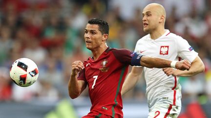 Le Portugais Cristiano Ronaldo à la lutte avec le Polonais Michal Pazdan, le 30 juin 2016 au stade Vélodrome de Marseille. (VALERY HACHE / AFP)