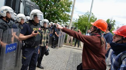 &nbsp; (Les manifestants portent des casques en hommage aux mineurs © Reuters)