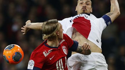 Le joueur du PSG&nbsp;Zlatan Ibrahimovic (D) &agrave; la lutte pour le ballon avec le joueur de Lille Simon Kjaer lors du match de Ligue 1 &agrave; Villeneuve-d'Ascq (Nord), le 10 mai 2014. (PASCAL ROSSIGNOL / REUTERS)