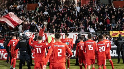 L'AS Cannes qui célèbre sa victoire contre le FC Dijon le 18 décembre 2021 lors du 32e de finale de la Coupe de France de Football. (XAVIER DUVOT / HANS LUCAS VIA AFP)