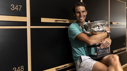 Rafael Nadal pose avec son trophée après avoir remporté la finale de l'Open d'Australie, le 30 janvier 2022 à Melbourne. (FIONA HAMILTON / TENNIS AUSTRALIA / AFP)