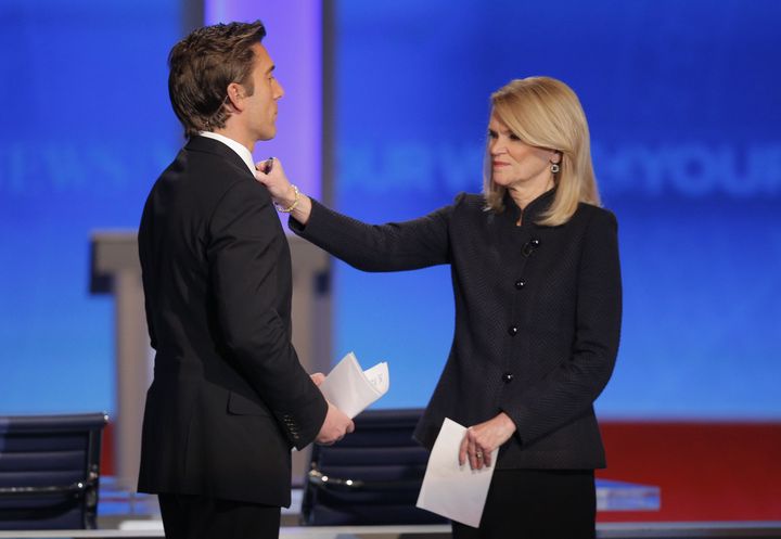 Martha Raddatz (à droite) ajuste la cravate de son confrère, le 19 décembre 2015, lors d'un débat entre les candidats à la primaire démocrate, à Manchester (New Hampshire, Etats-Unis).&nbsp; (BRIAN SNYDER / REUTERS)