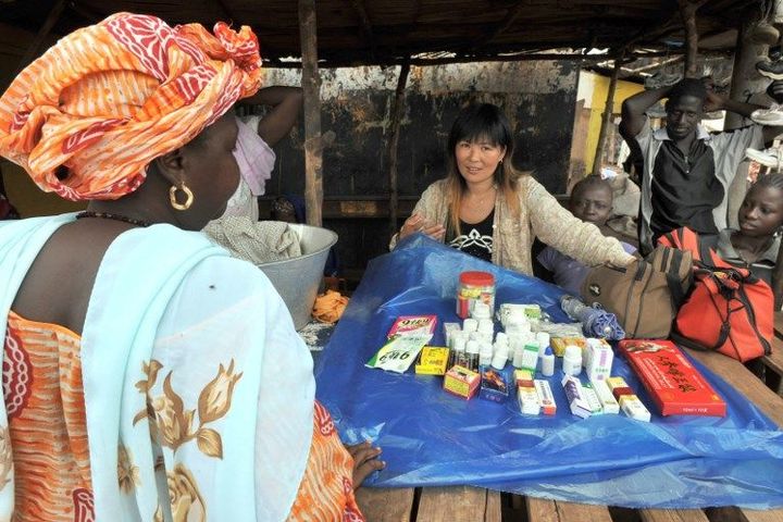 Une Chinoise en train de vendre des produits médicinaux sur le marché de Kamsar, au nord de Conakry, capitale de la Guinée. (GEORGES GOBET / AFP)