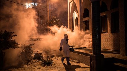 A titre préventif, jour et nuit, les employés municipaux de Dakar pulvérisent des produits désinfectants dans des lieux auparavant très fréquentés comme les marchés ou les mosquées.&nbsp; &nbsp; &nbsp; (JOHN WESSELS / AFP)