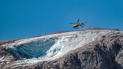 L'hélicoptère des secours italiens a effectué des rotations, lundi 4 juillet, pour tenter de retrouver les dernières personnes portées disparues au lendemain de l'effondrement du glacier de la Marmolada. (PIERRE TEYSSOT / AFP)