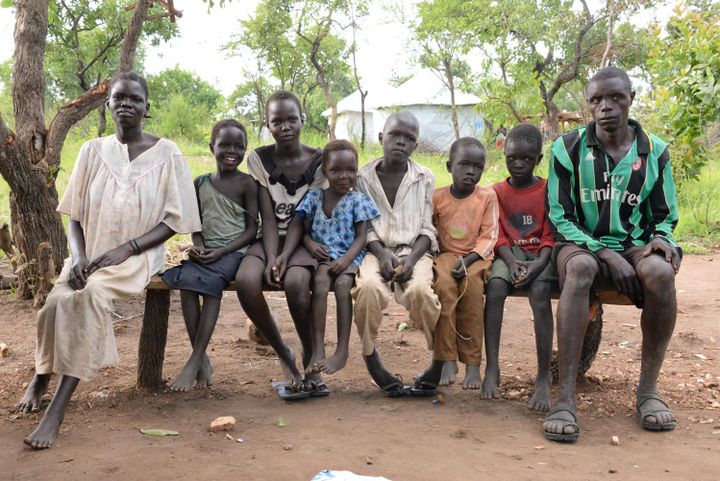 Un réfugié sud-soudanais de 13 ans, Peter Yat (M) est assis à côté de ses frères et de sa famille adoptive dans le camp de réfugiés d'Imvepi, en Ouganda, le 27 juin 2017. Plus de deux millions de personnes ont fui la guerre civile au Soudan du Sud. un million d'entre eux en Ouganda.  (Gioia Forster/DPA/AFP)