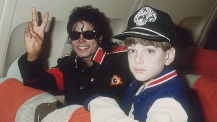 Michael Jackson et James Safechuck dans l'avion de tournée de la star, le 11 juillet 1988. (DAVE HOGAN / HULTON ARCHIVE / GETTY IMAGES)