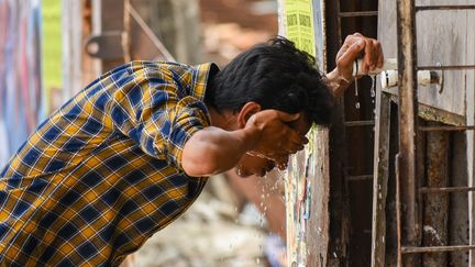 Un homme tente de se rafraîchir lors d'un épisode de forte chaleur à Kolkata (Inde), le 23 mars 2023. (DEBARCHAN CHATTERJEE / NURPHOTO / AFP)