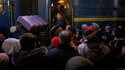 Des personnes se pressent dans un train d'évacuation à la gare centrale de Kiev (Ukraine), le 28 février 2022. (DIMITAR DILKOFF / AFP)