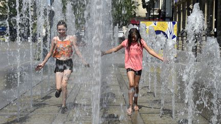 Des enfants jouent dans des fontaines publiques pour se rafraîchir à Valenciennes le 27 juillet 2018. (FRANCOIS LO PRESTI / AFP)