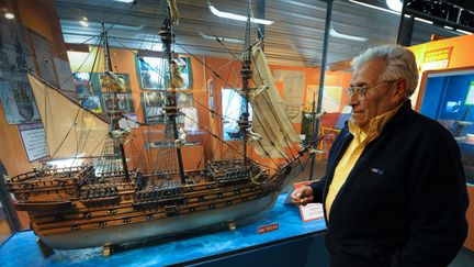 Le plongeur et chercheur de trésors argentin Ruben Collado, le 29 avril 2010 dans un musée de Montevideo (Uruguay), devant une maquette du "Lord Clive", un navire anglais coulé en 1763 par les Espagnols. (DANIEL CASELLI / AFP)