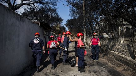 Des équipes de secours à Mati, en Grèce, le 25 juillet 2018.&nbsp; (ANGELOS TZORTZINIS / AFP)