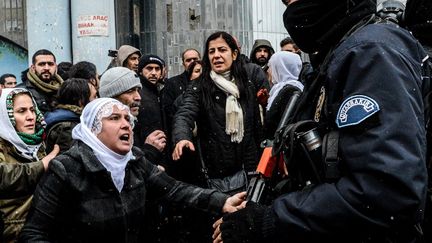 31 Décembre 2015 à Diyarbakir dans la région à forte population kurde de Turquie. Des femmes devant des policiers turcs. Le couvre feu imposée dans la région depuis le 2 décembre a été levé. Il témoigne de la tension qui règne entre le régime d'Erdogan et la population kurde qui a voté pour le parti d'opposition HDP. Selon ce parti, 56 civils ont été tués durant ce couvre feu. «Contrairement aux affirmations selon lesquelles ils s'agirait de garantir  la paix et la sécurité, les autorités créent la peur et la terreur parmi les  gens, tuant sans compter des civils et détruisant l'héritage culturel», a  affirméle HDP. (ILYAS AKENGIN / AFP)