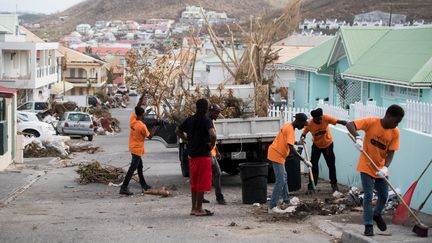 Des habitants de Saint-Martin nettoient les rues de Marigot, le 12 septembre 2017, après le passage de l'ouragan Irma sur l'île. (MARTIN BUREAU / AFP)