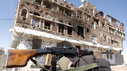 Un fid&egrave;le du leader&nbsp;Sadiq al-Ahmar marche dans Sanaa (Y&eacute;men) ravag&eacute; par les r&eacute;cents affrontements avec les forces gouvernementales, le 20 d&eacute;cembre 2011. (KHALED ABDULLAH / REUTERS)