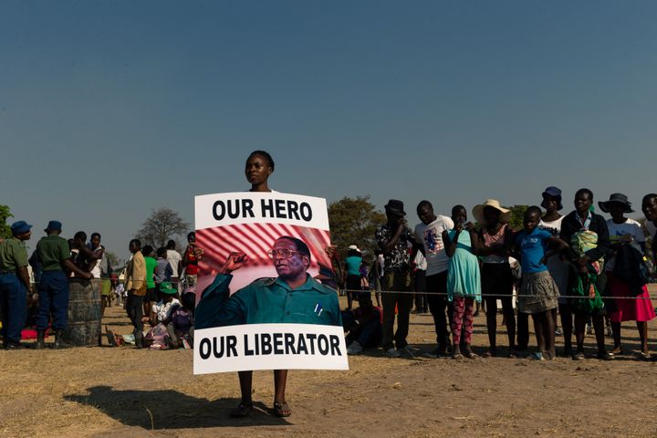 Une jeune Zimbabwéenne tient une pancarte en hommage à Robert Mugabe, "notre héros, notre libérateur", mort&nbsp;dans un luxueux hôpital de Singapour où il avait l'habitude de se faire soigner (photo du 16 septembre 2019). (JEKESAI NJIKIZANA / AFP)