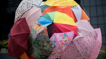 Les parapluies servent &agrave; la fois &agrave; prot&eacute;ger les manifestants des gaz lacrymog&egrave;nes, comme dimanche, et de la pluie. A tel point que le mouvement est baptis&eacute; "r&eacute;volution des parapluies". (ALEX OGLE / AFP)