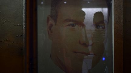 L'ombre de deux personnes à travers une affiche électorale du Premier ministre Pedro Sanchez, au siège du parti socialiste espagnol, le PSOE, à Madrid, le 28 mai 2023. (OSCAR DEL POZO / AFP)