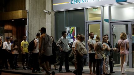 Jusqu'&agrave; tard dans la nuit, dimanche 28 juin, les Grecs ont fait la queue devant les banques pour tenter de retirer leurs &eacute;conomies. Depuis lundi, les retraits sont limit&eacute;s &agrave; 60 euros par jour.&nbsp; (PANAYIOTIS TZAMAROS / NURPHOTO / AFP)