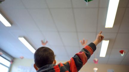 Un &eacute;l&egrave;ve d'une classe de primaire l&egrave;ve le doigt pour prendre la parole dans une &eacute;cole de Mulhouse (Haut-Rhin), en f&eacute;vrier 2013. (SEBASTIEN BOZON / AFP)