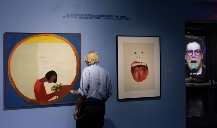 Visitor in front of works by Emma Amos (left) and Marisol Escobar (right) during the exhibition 