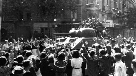 25 août 1944, des Parisiens acclament des chars de la 2e Division blindée du général Leclerc entrant dans Paris. (COLL-DITE/USIS / AFP)