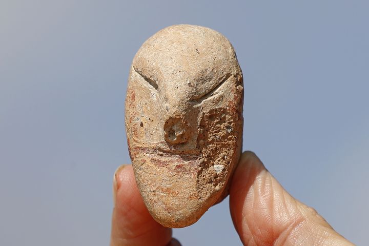 Une rare figurine à visage humain retrouvée lors des fouilles sur le site&nbsp;archéologique de En Esur (Ein Asawir), tout près de la ville de Harish,&nbsp;où ont été exhumés les restes d'une ville de&nbsp;5000 ans. (JACK GUEZ / AFP)